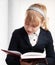 Closeup portrait of blond Caucasian schoolgirl reads textbook