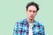 Closeup portrait of clever puzzlement young man in casual blue checkered shirt and headband standing, looking away and thinking to