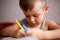 Closeup portrait of cute little boy drawing picture. The beautiful, emotional face of a child of four years