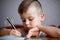Closeup portrait of cute little boy drawing picture. The beautiful, emotional face of a child of four years