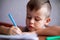 Closeup portrait of cute little boy drawing picture. The beautiful, emotional face of a child of four years