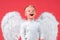 Closeup portrait of cute toddler boy in a white shirt with white wings as a Cupid, Saint Valentines Day card, kids