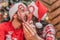 Closeup portrait of defocused amorous kissing couple holding a candy heart on the forefront.