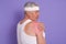 Closeup portrait of elderly sportsman wearing t shirt and headband, white haired mature male posing sideways and touching his