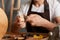 Closeup portrait of faceless craftsman wearing white t-shirt and brown apron working, joinery work, wood carving, chisels for