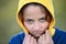Closeup portrait of frozen little thin caucasian kid in yellow and blue hoodie freeze on cold outdoor weather with health danger
