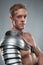 Closeup portrait of Gladiator in armour over grey