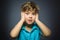 Closeup Portrait of handsome boy with astonished expression while standing against grey background