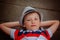 Closeup portrait handsome boy in hat lying on skateboard in summer