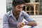 Closeup portrait handsome man looking to his wristwatch frustrated that his girl friend partner client is late to the date meeting