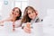 Closeup portrait happy amazing girls in knitted sweaters relaxing on white bed with cups of coffee. Perfect morning