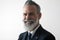 Closeup portrait of happy bearded middle aged gentleman wearing trendy suit over empty white background. Studio shot