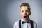 Closeup Portrait of happy boy going surprise on gray background