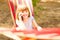 Closeup portrait of happy little child girl talking on phone lying on hammock in summer forest. Positive emotions