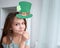 Closeup portrait of a happy preteen caucasian girl in an emerald leprechaun St. Patrick`s Day hat