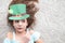 Closeup portrait of a happy preteen caucasian girl in an emerald leprechaun St. Patrick`s Day hat