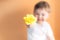 Closeup portrait happy smiling boy with orange rose. Beautiful little boy toddler giving a flower Mother`s day concept. boy