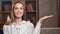 Closeup portrait happy woman pointing hand at copy space sitting on couch at evening living room