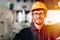 Closeup portrait happy worker nerdy glasses working in industry factory wearing safety suit cloth and yellow helmet