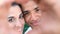 Closeup portrait of happy young multiethnic couple smiling and doing heart sigh with their hands together - love and friendship