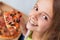 Closeup portrait of a happy young teenager girl eating a slice o