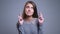 Closeup portrait of hopeful young caucasian female looking at camera and having her fingers crossed anxiously