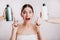 Closeup portrait of joyful girl posing without makeup on white background. Woman chose which shampoo is best to use.