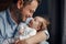 Closeup portrait of middle age bearded Caucasian father hugging and kissing newborn baby. Male man parent holding child. Authentic