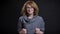 Closeup portrait of middle-aged extravagant redhead female in glasses being excited and celebrating success while