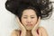 Closeup portrait of moody asian women  lying on ground with black long hair. acting upset , unhappy