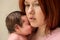 Closeup portrait of mother with worried face embracing newborn baby daughter. Post-natal depression concept