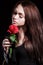 Closeup portrait of a pale beautiful young woman with a red rose