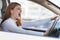 Closeup portrait of pissed off displeased angry aggressive woman driving a car shouting at someone with hand fist up. Negative