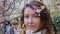 Closeup portrait of pretty girl in park with blooming japanese sakura trees. Romantic young brunette in white sweater