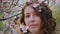 Closeup portrait of pretty girl in park with blooming japanese sakura trees. Romantic young brunette in white sweater