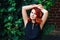 Closeup portrait of relaxing middle aged white caucasian woman with waved red hair in black dress looking in camera