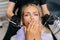 Closeup portrait of scared blonde young woman closing mouth by fear in dental clinic, afraid of treatment. Cropped shot