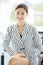 Closeup portrait shot of Asian young pretty successful friendly female businesswoman wears black and white stripe suit sit cross