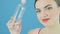 Closeup Portrait of Smiling Cute Brunette with Bottle of Water in Hand on Blue Background in Studio.