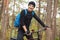 Closeup portrait of smiling cyclist man riding mountain bike on trail in park or forest, enjoing fresh air and beautiful nature,