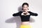 Closeup portrait smiling happy young woman making heart sign, symbol with hands white wall background. Warm color. Hipster. Love.