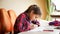 Closeup portrait of teenage girl listening to music doing homework in bedroom