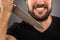 Closeup portrait of a threatening man with beard holding a knife