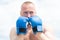 Closeup portrait of tough male boxer posing in boxing gloves. Professional fighter ready for boxing match. Sportsman