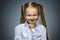 Closeup Portrait tricky girl looks at the camera isolated on grey