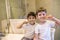 Closeup portrait of twins kids toddler boy brother in bathroom toilet washing face hands brushing teeth with toothbrush playing