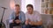 Closeup portrait of two adult handsome attractive men playing video games sitting on the couch indoors