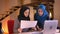 Closeup portrait of two successful muslim businesswomen in hijabs comparing the data on different graphs using the