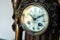 A closeup portrait of the vintage clock face of an old retro clock made of wood and metal with beautiful clock hands and numbers