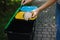 Closeup portrait woman hand throwing crumpled paper bag in recycling bin. Outdoors recycling bins different colours